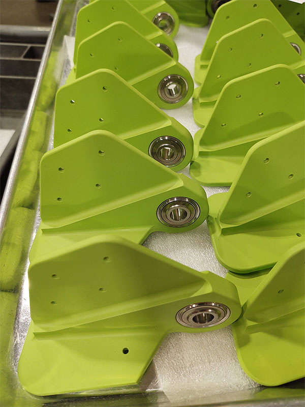 A group of green plastic handles on a tray.
