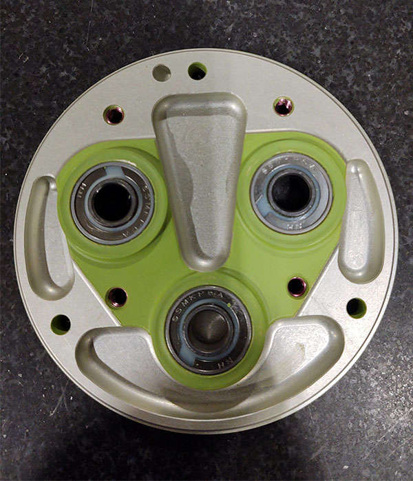 A green plate with four holes on it.