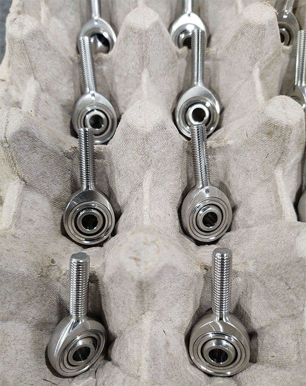 A group of metal nuts and bolts in a box.