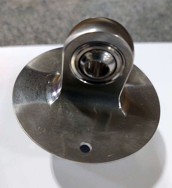 A stainless steel ball bearing on a white surface.