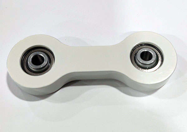 A white ball bearing for a machine on a white surface.