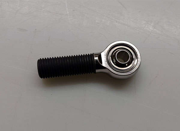 A black bolt and nut on a white surface.