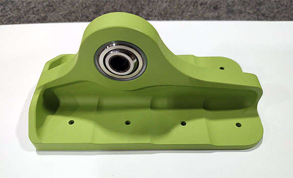 A green plastic holder with a ball on it.