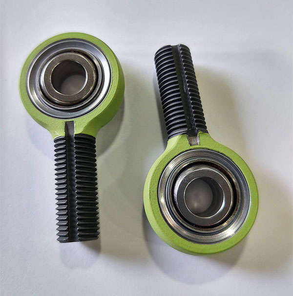 Two green bearings on a white surface.