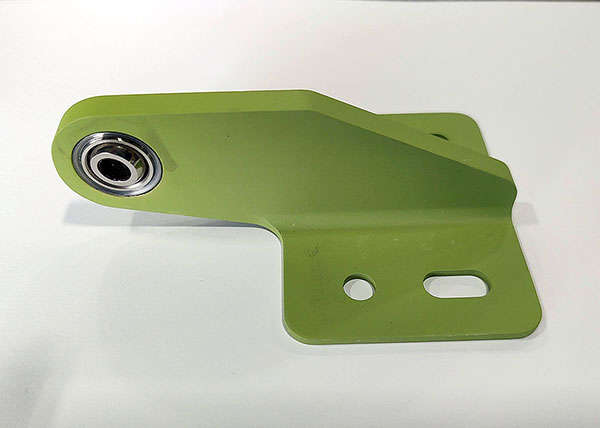 A green plastic bracket on a white surface.