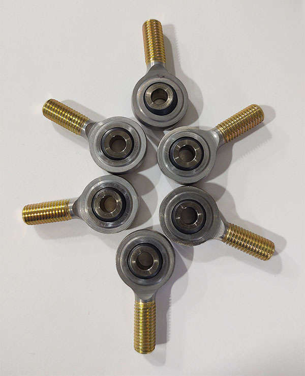 A group of metal bolts and nuts on a white surface.