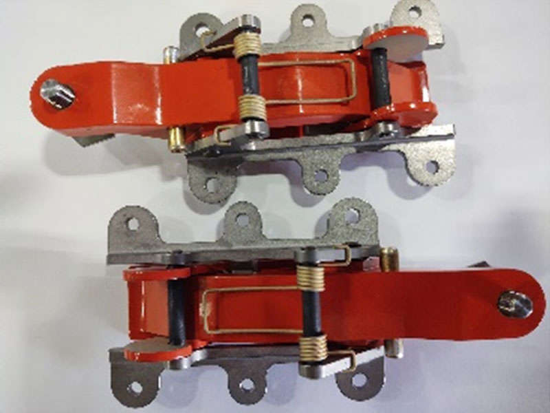 Manufacturing two red metal clamps on a white surface.
