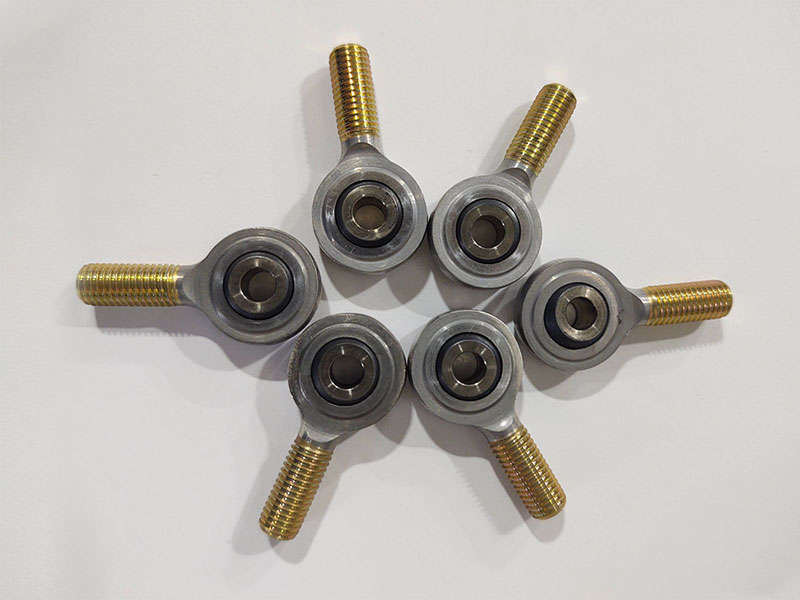 Manufacturing group of metal bolts and nuts on a white surface.