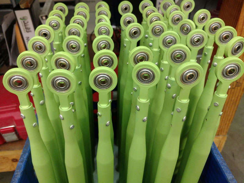 Manufacturing a collection of green rollers in a blue container.