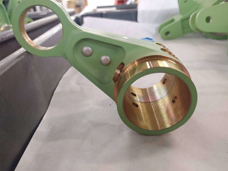 An assembled green metal object is placed on a table.