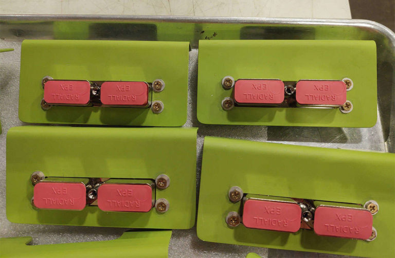 A tray with an assembly of green and pink buttons.