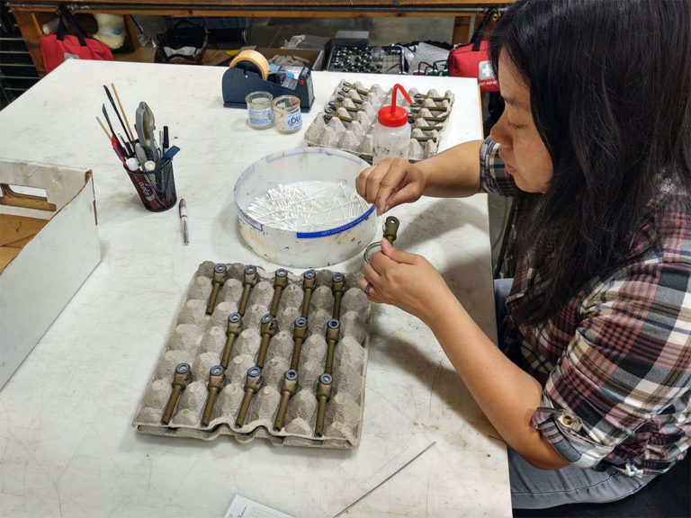 A woman specializing in assembly and integration working in a workshop.