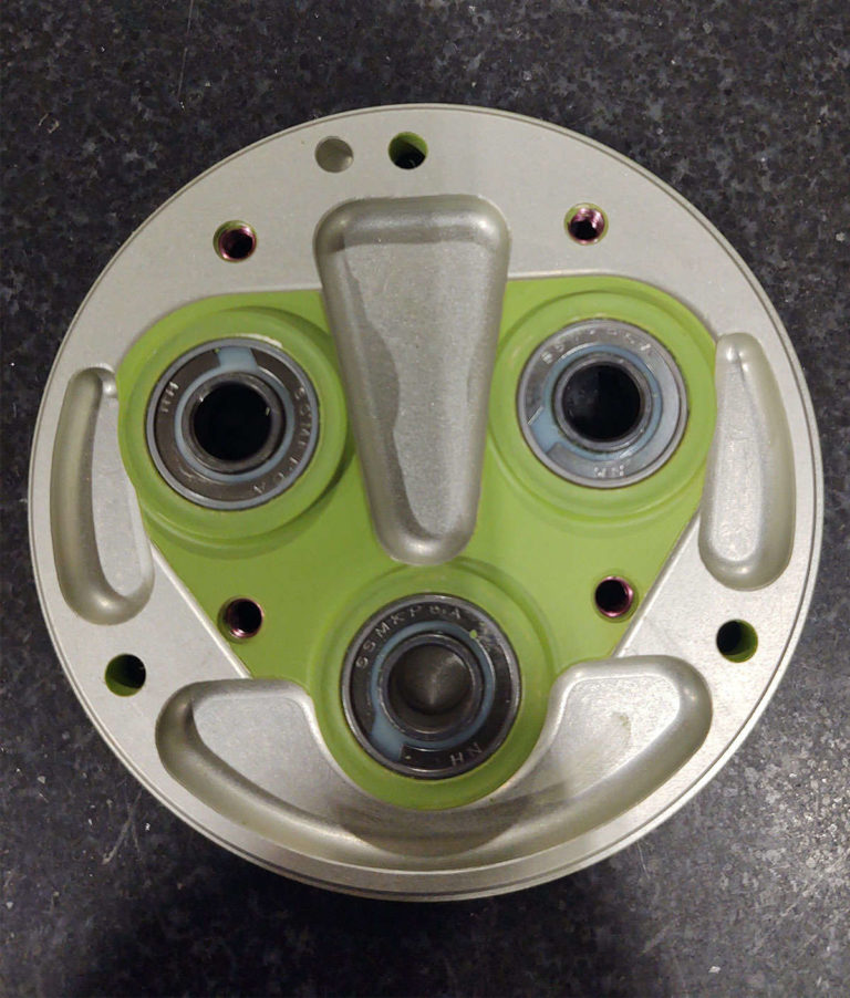 A metal plate with four holes on it used for assembly and integration purposes.